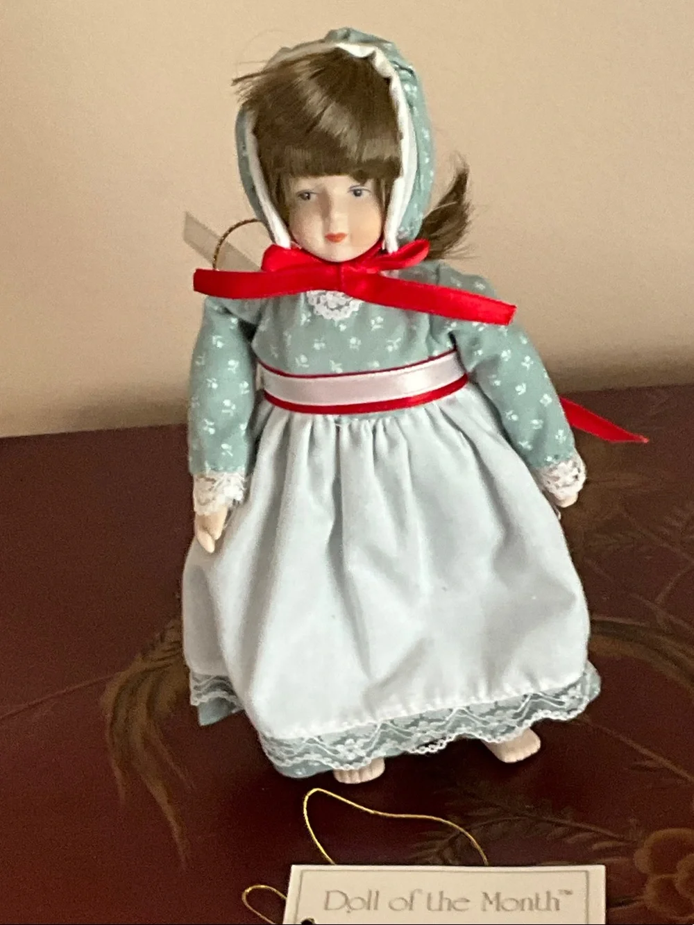 Porcelain Doll in Light Blue Dress with Red Ribbon Accents